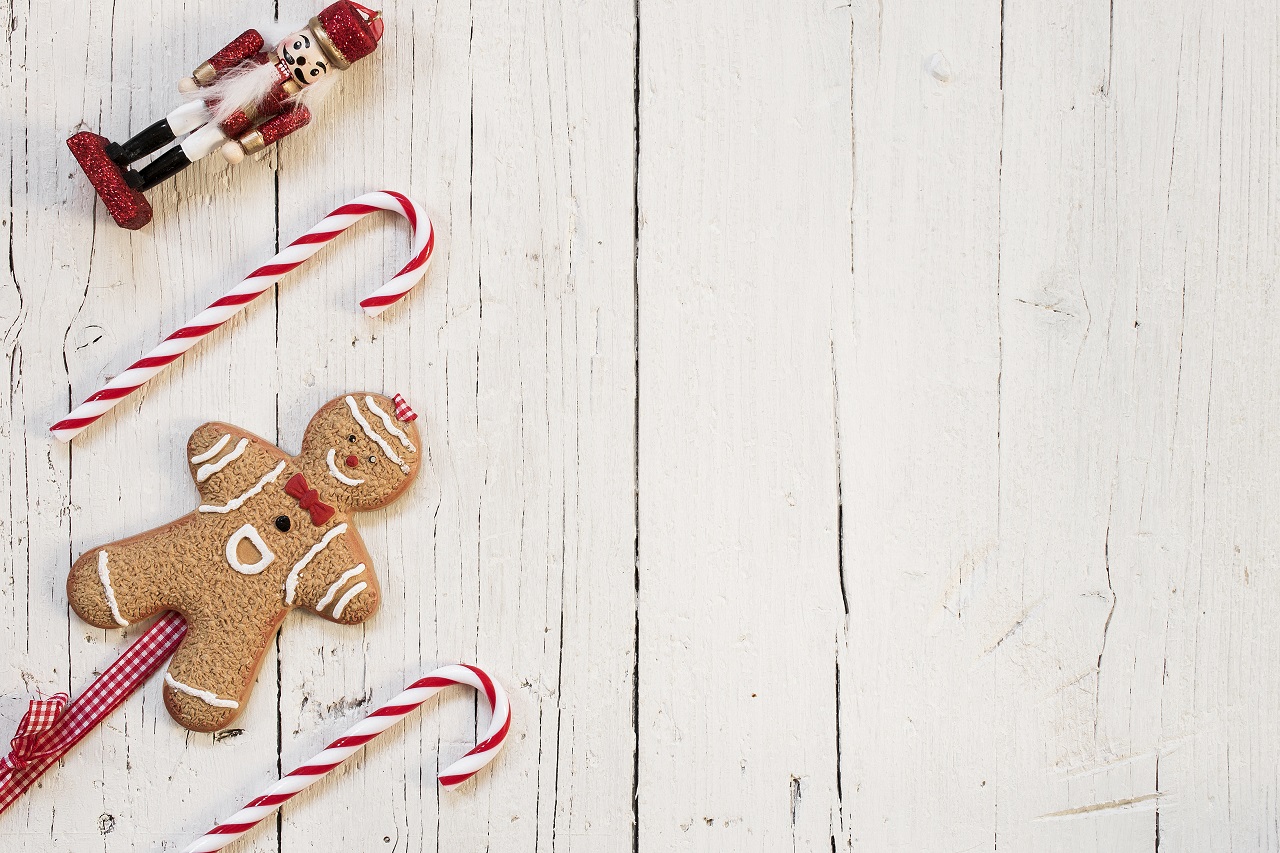 A plastic gingerbread man on top of a table with a nutcracker and candy cane