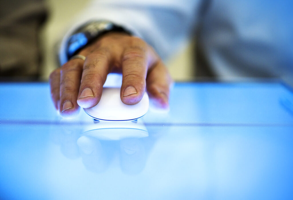 A man's hand holding a mouse