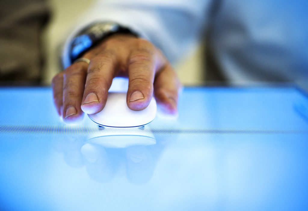 A man's hand holding a mouse