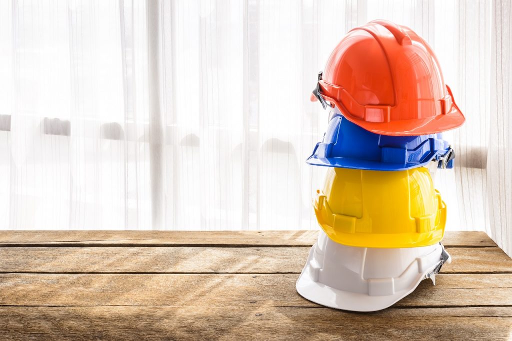Four plastic hardhats stacked on top of each other on a table