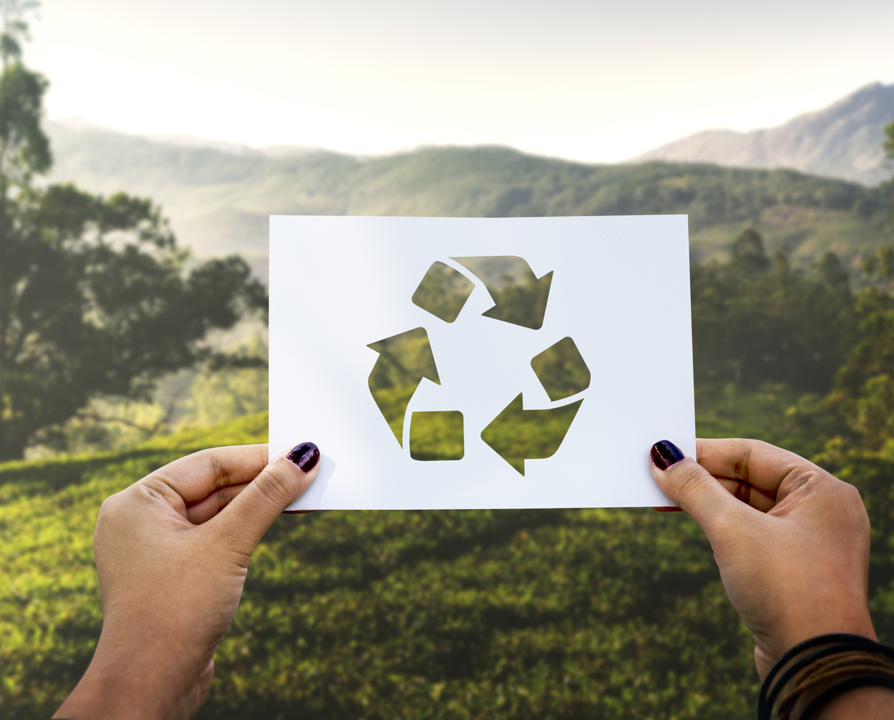 A person holding up a recycling sign