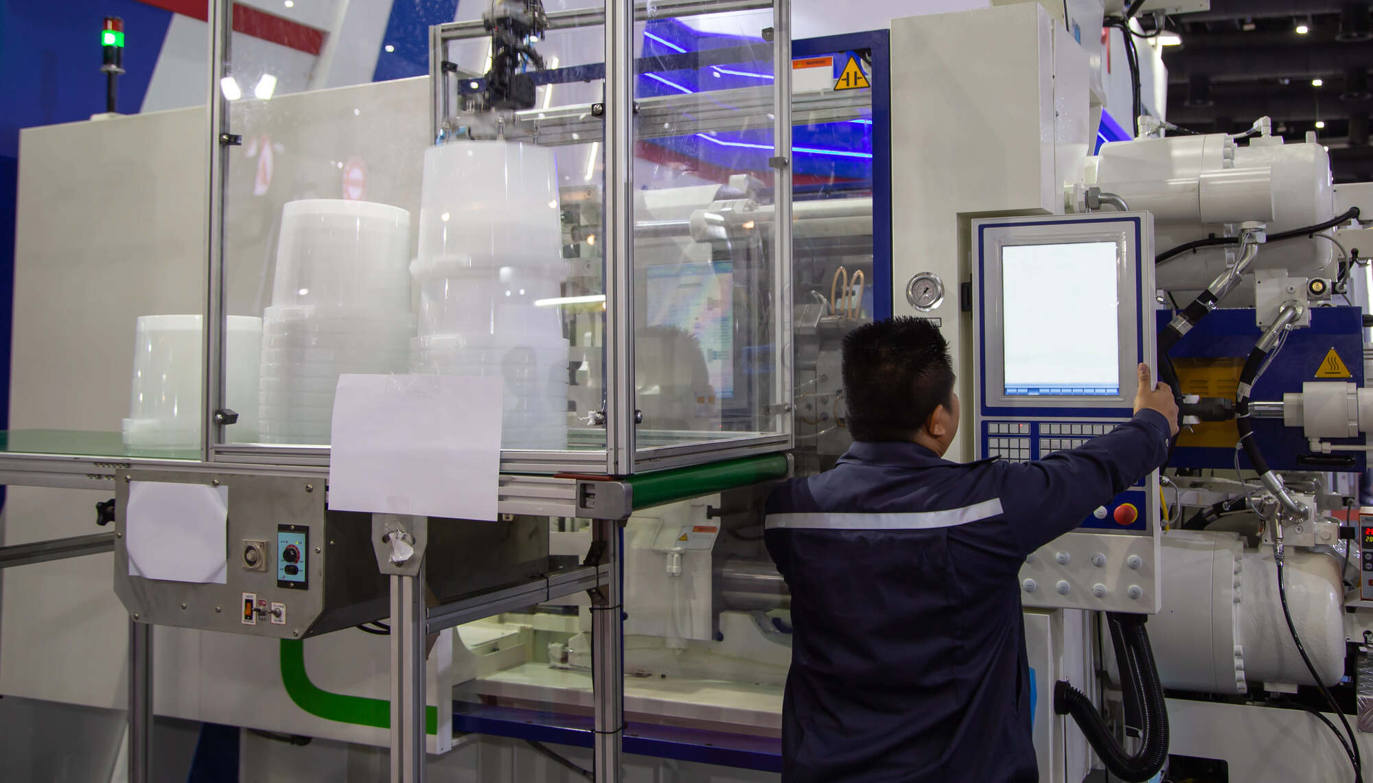 An engineer operating an injection molding machine