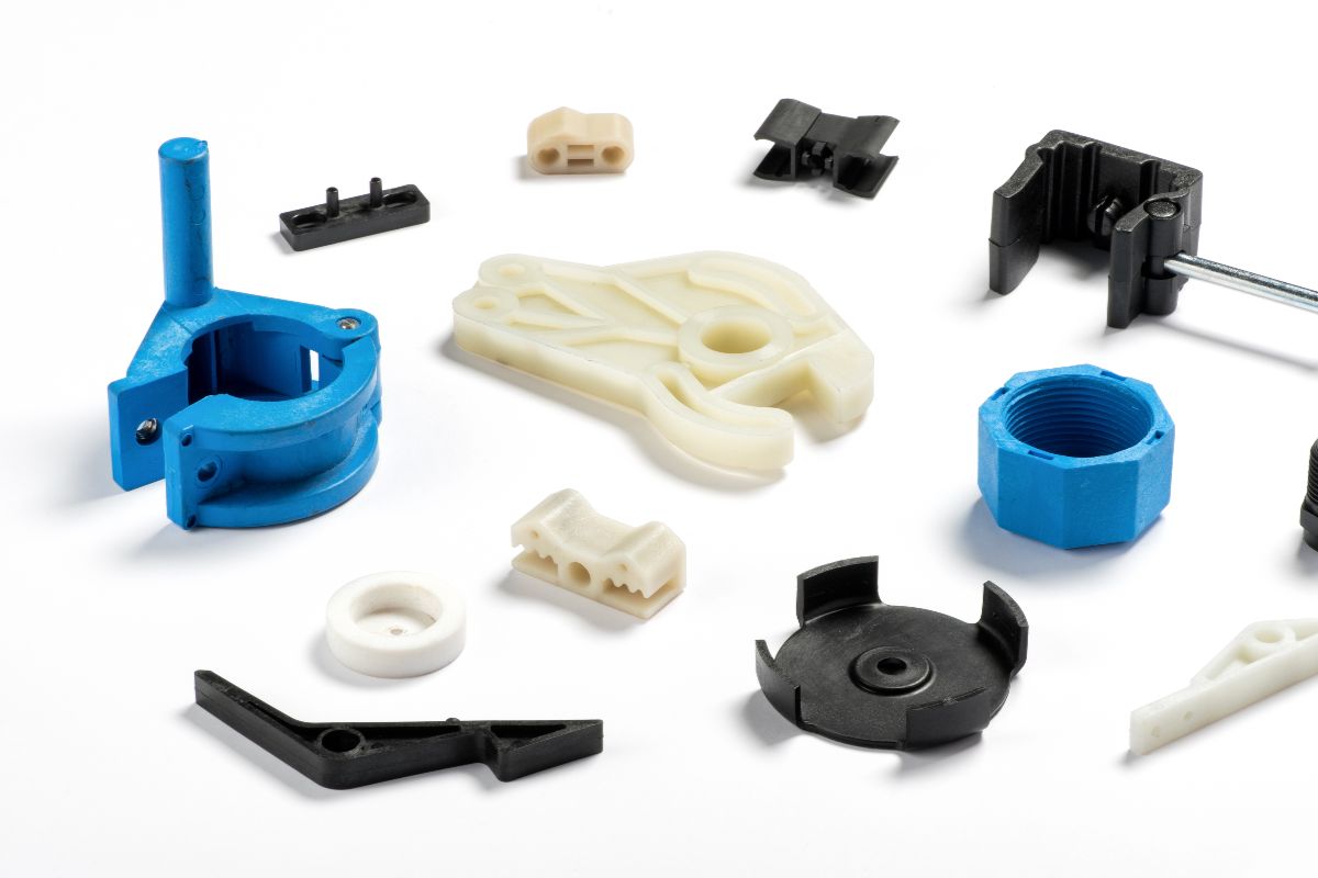 Various custom injection molded plastic components and industrial parts displayed on a white background.