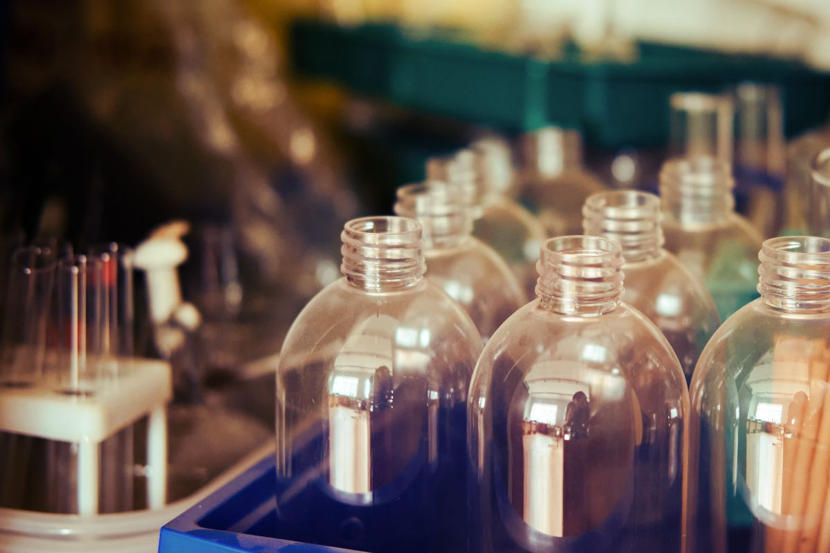 Clear plastic bottles arranged on a production line inside a plastic packaging manufacturing facility.